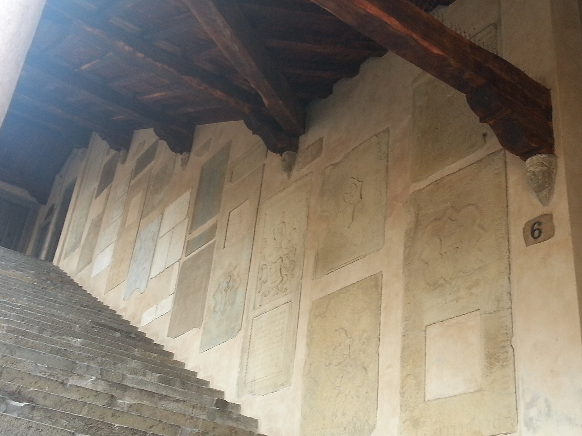 Scalone monumentale italiano con lapidi incise sulle pareti.
